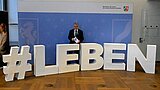 NRW-Innenminister Herbert Reul steht vor einem Rollup des Innenministeriums. Vor ihm ist ein Aufsteller mit dem Schriftzug Hashtag Leben zu sehen.
